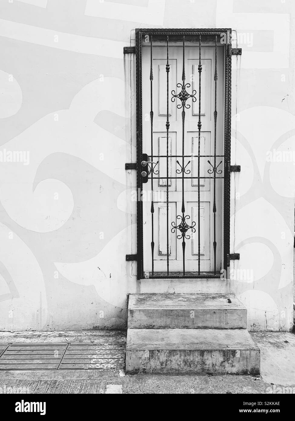 Cement steps and ornate barred door into building in Chinatown Singapore Stock Photo