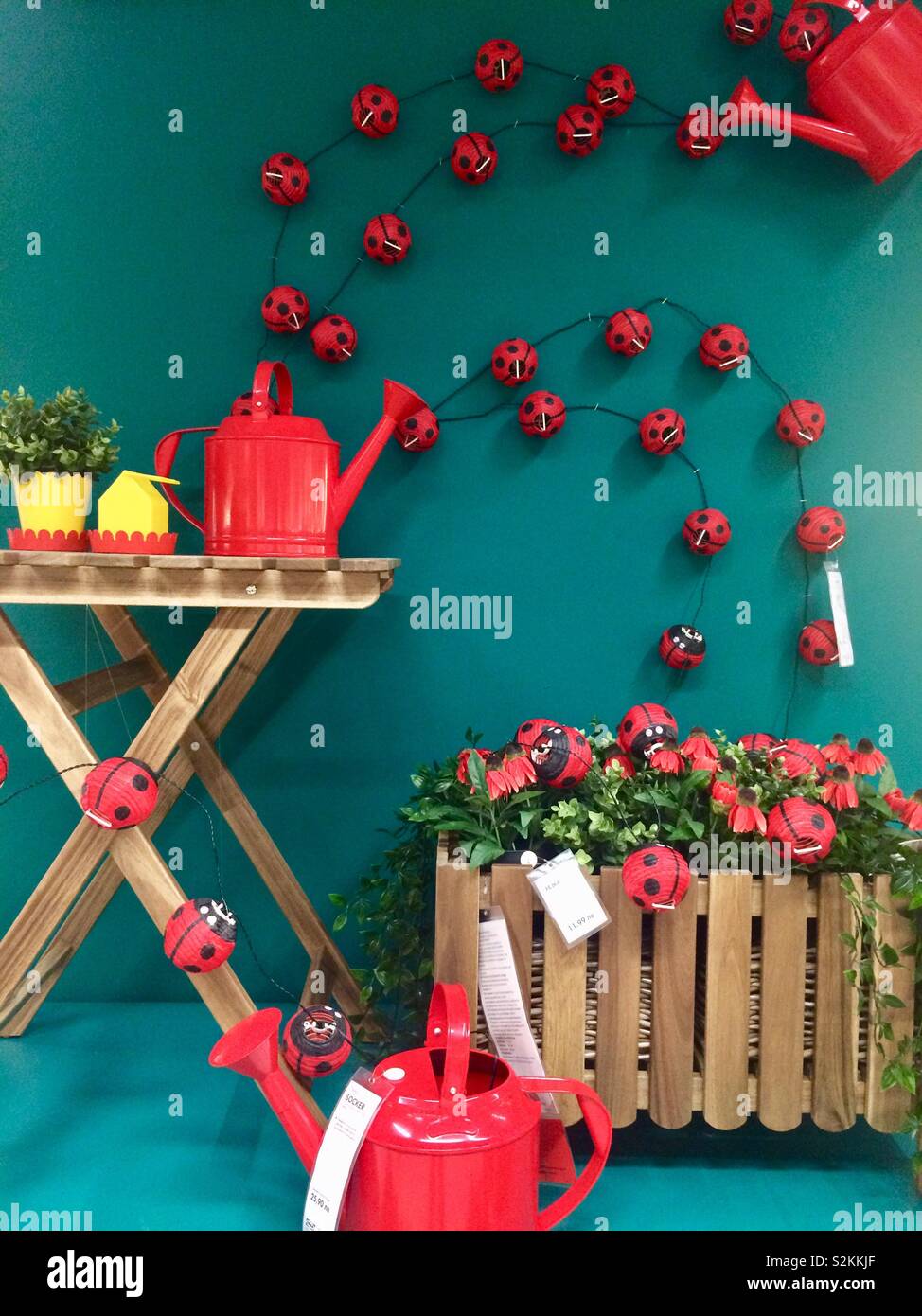 Ikea springtime decoration showroom layout with ladybirds mini lamps on teal coloured wall. Stock Photo
