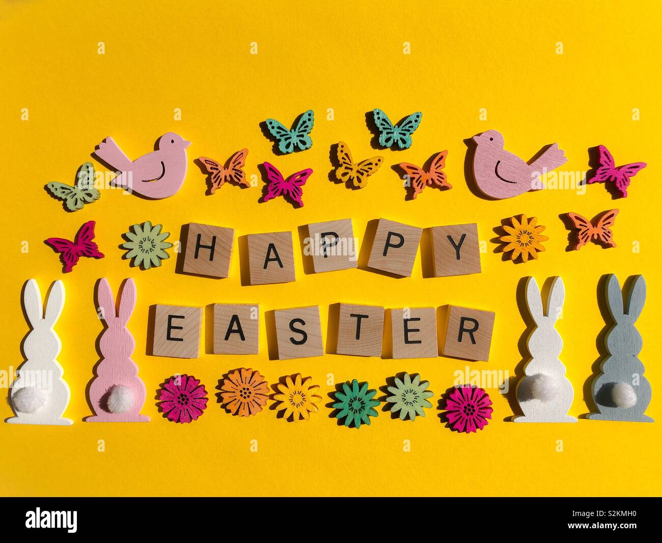 Happy Easter, in wooden letters with bunny rabbits, birds, flowers and butterflies Stock Photo