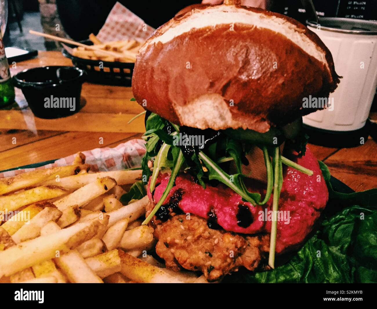Vegan burger on table in restaurant. Vegan fast food. Vegan junk food - Smartphone Captured Stock Image