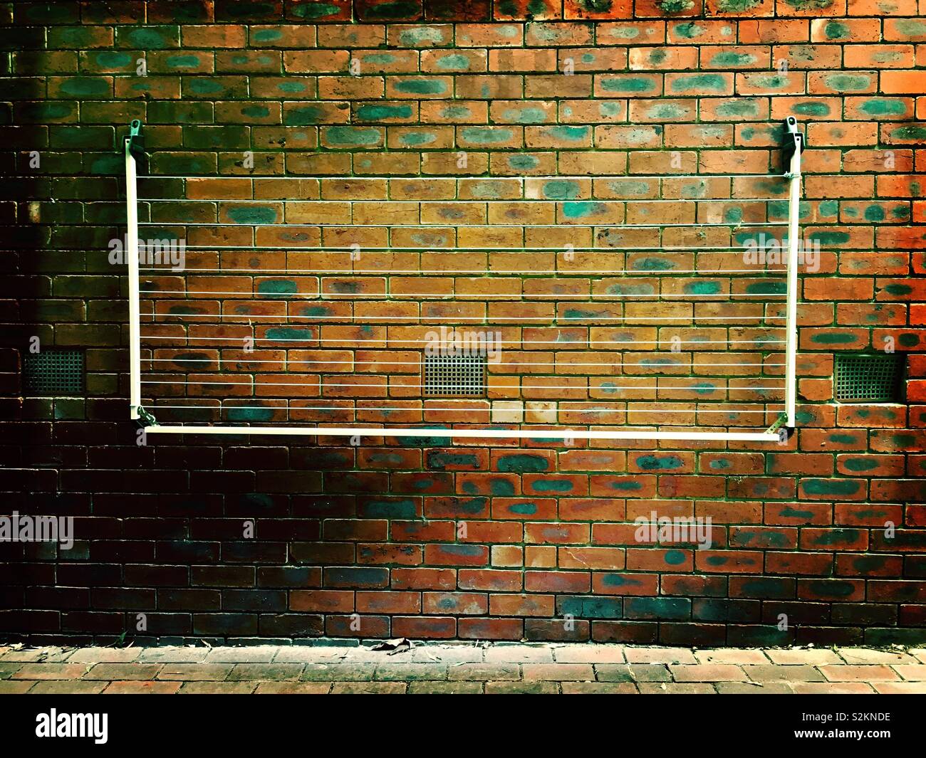 Retractable clothes line attached to a brick wall. Stock Photo