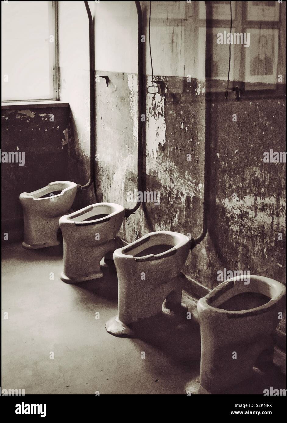 Toilets in an open room used by prisoners at the Nazi Auschwitz Concentration Camp in German Occupied Poland during WW2. Auschwitz is now a Memorial & a UNESCO World Heritage Site. - Smartphone Captured Stock Image