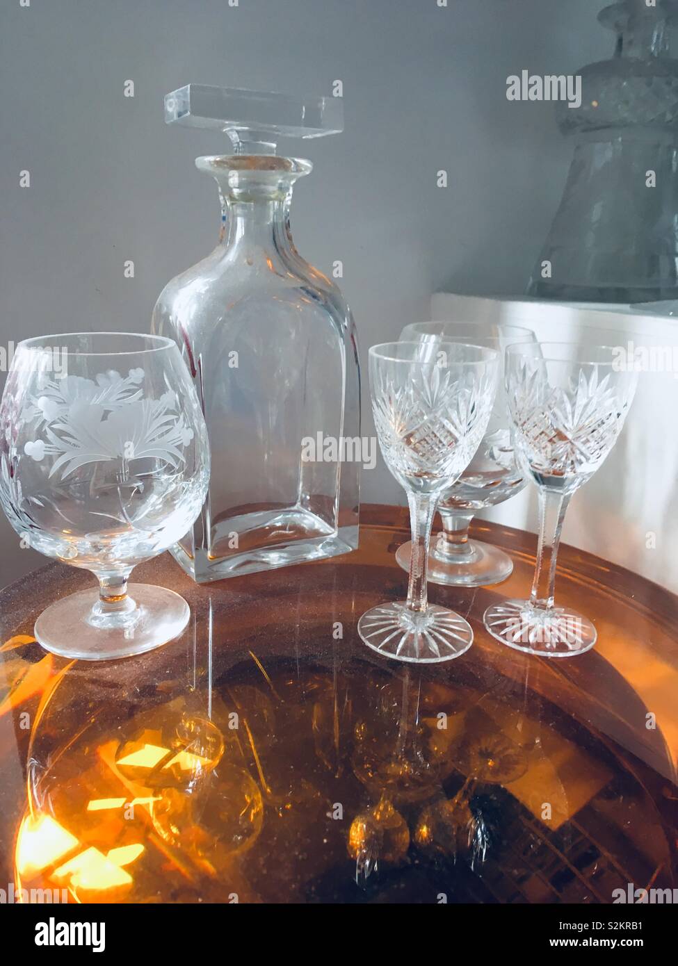 Brandy decanter and glasses on orange glass reflective table - Smartphone Captured Stock Image