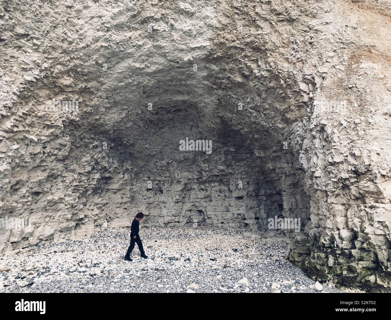 Boy in Cliff cave Pegwell Bay Kent UK Stock Photo