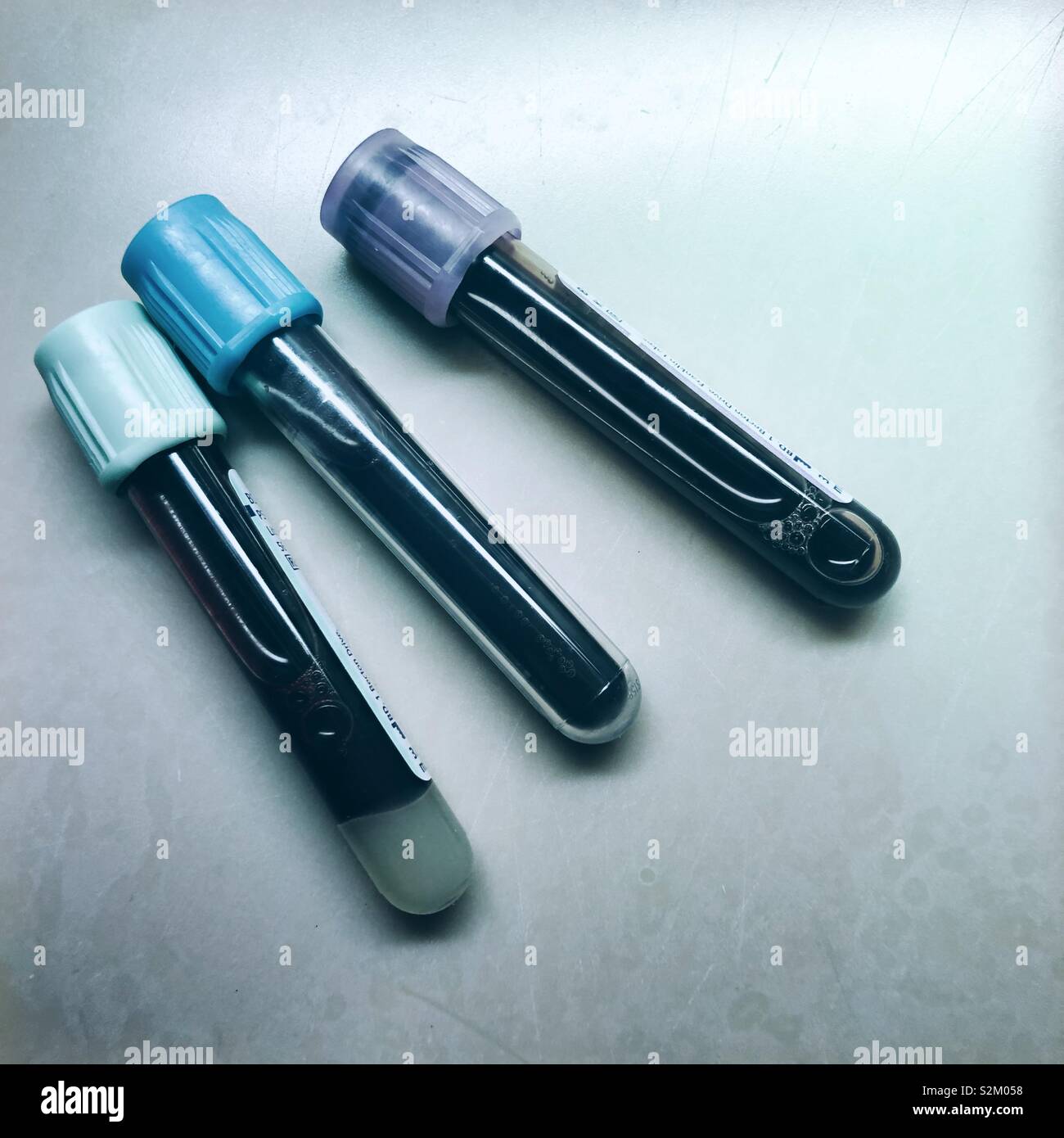 A cool toned image of three glass vials of blood - Smartphone Captured Stock Image