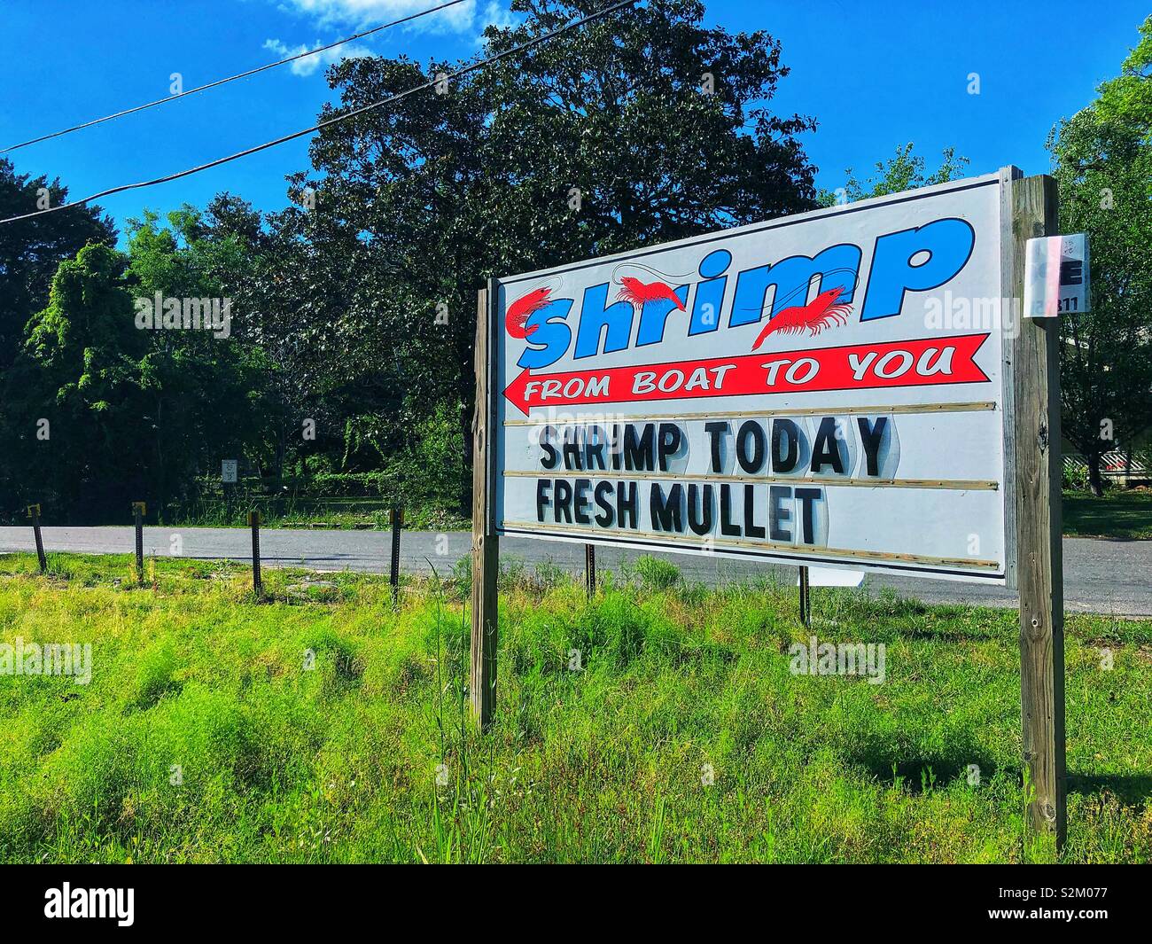 A sign advertises fresh shrimp and mullet straight from the boat in BayouLa Batre, Alabama. Stock Photo