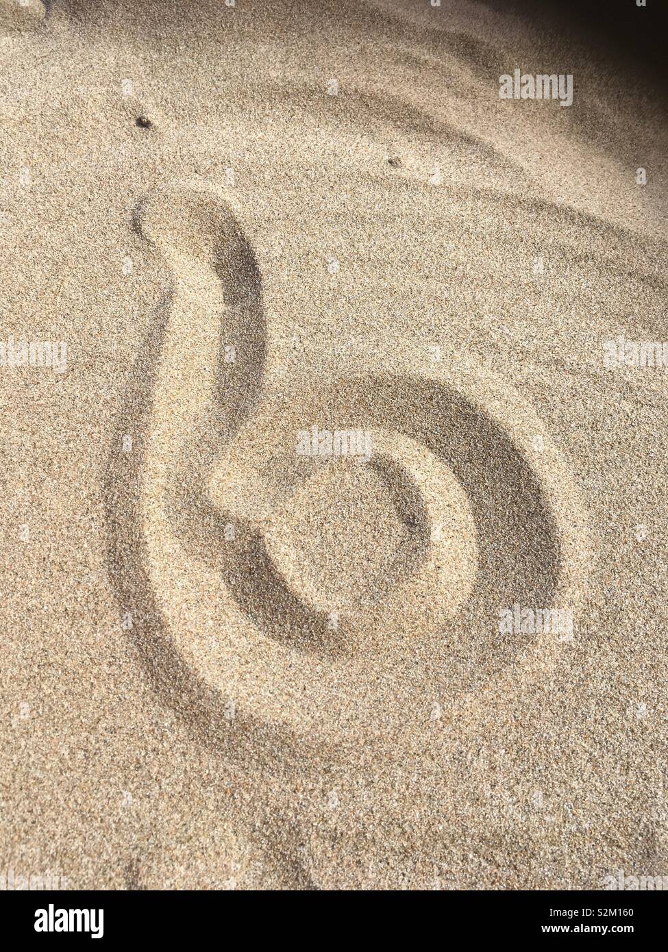 Small letter ‘b’ written in sand Stock Photo