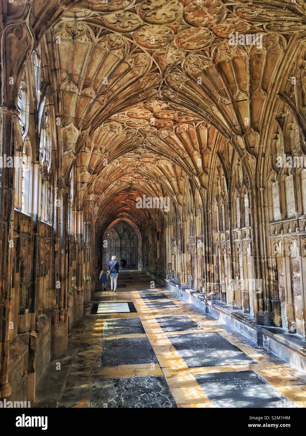 Walkway through Gloucester  cathedral with beautiful light coming through the windows. Also where they filmed parts of Harry Potter movies Stock Photo