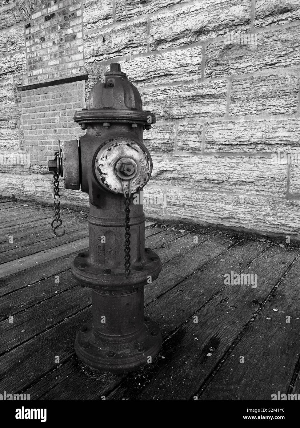 Black and white version of an old fire hydrant on a boardwalk in Minneapolis. Stock Photo