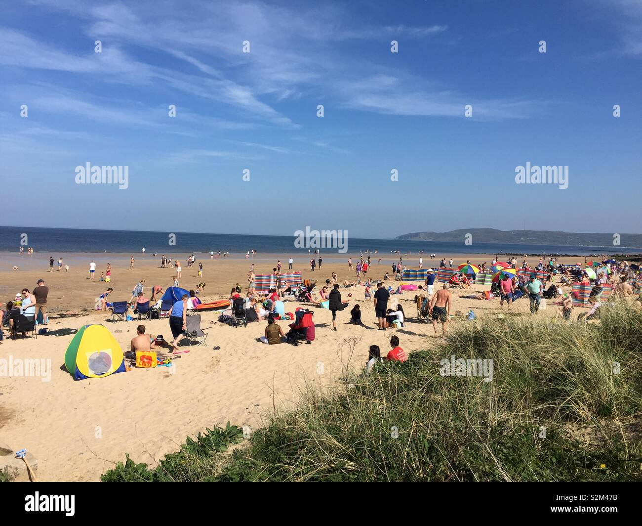 Holiday makers enjoy the sun on the beach at Benllech, Anglesey on