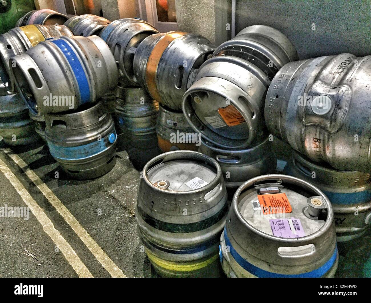 Multiple metal beer kegs stacked outdoors, showcasing brewery storage and distribution. Industrial barrels used for pubs and draft beer system - Smartphone Captured Stock Image