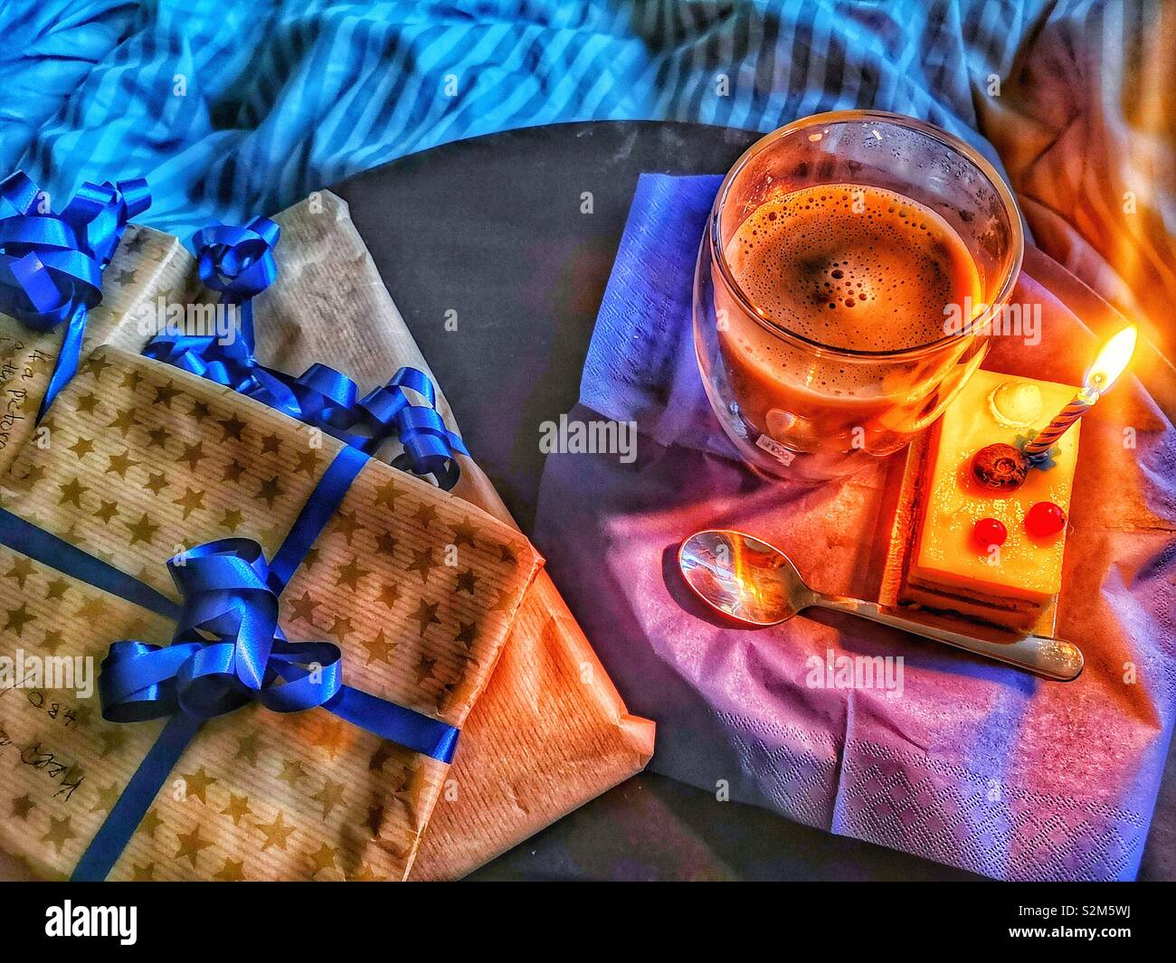 Swedish birthday. Presents, coffee and cake with candle in bed, Stockholm, Sweden. Traditionally you are woken by family singing happy birthday and bringing presents to open in bed and often breakfast Stock Photo