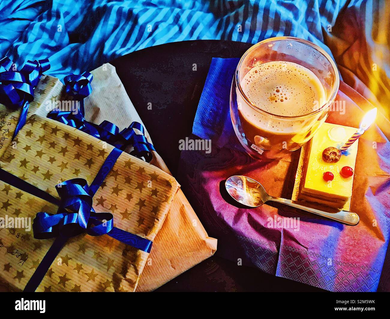 Swedish birthday. Presents coffee and cake with candle in bed, Stockholm, Sweden. Traditionally you are woken by family singing happy birthday and bringing presents to open in bed and often breakfast Stock Photo