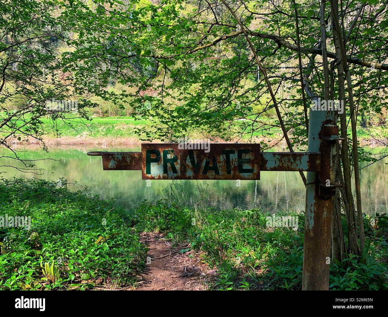 Private Gate in forest, showing signs of rust Stock Photo - Alamy