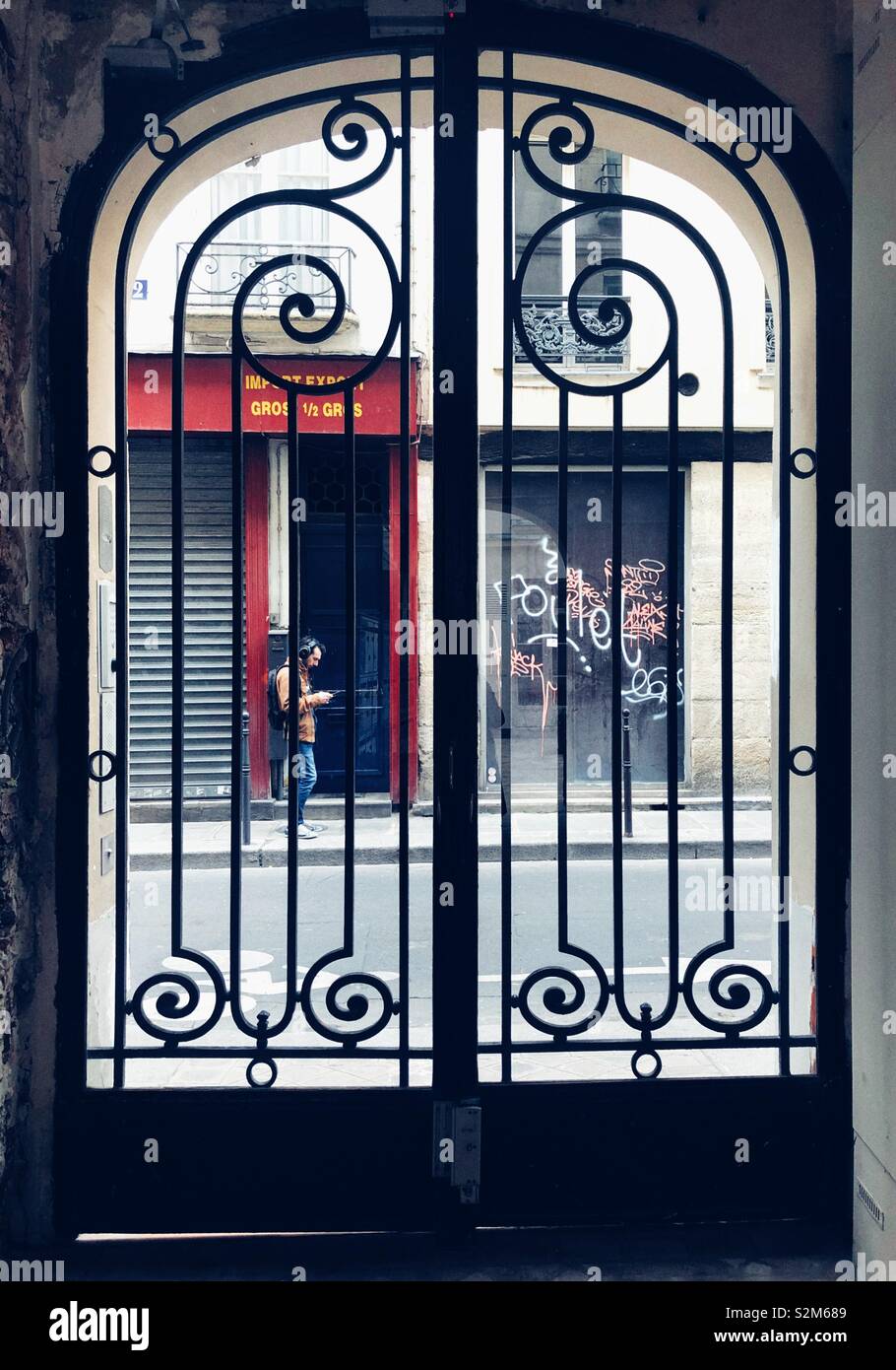 Typical Parisian street seen from courtyard with metal gates in Marais neighborhood Stock Photo