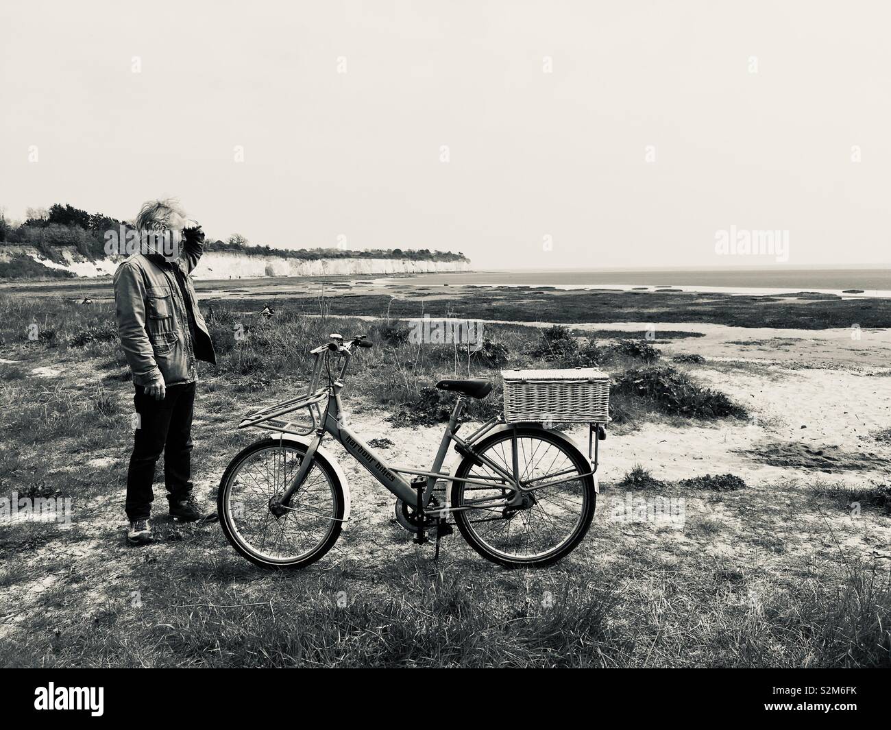 Man on beach with bike Stock Photo