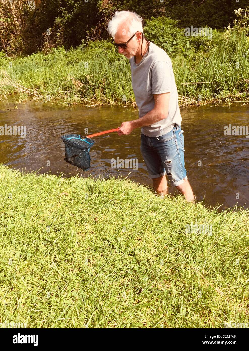 Man fishing with kids net - Smartphone Captured Stock Image