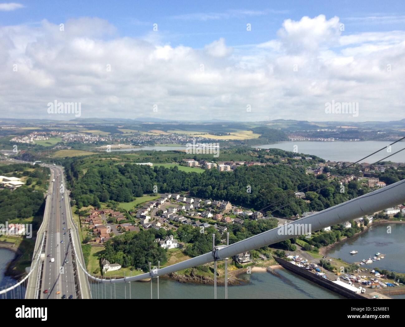 High level view from top of North tower gantry looking down on road deck of Forth Road Bridge overlooking North Queensferry and Firth of Forth, Scotland, UK Stock Photo
