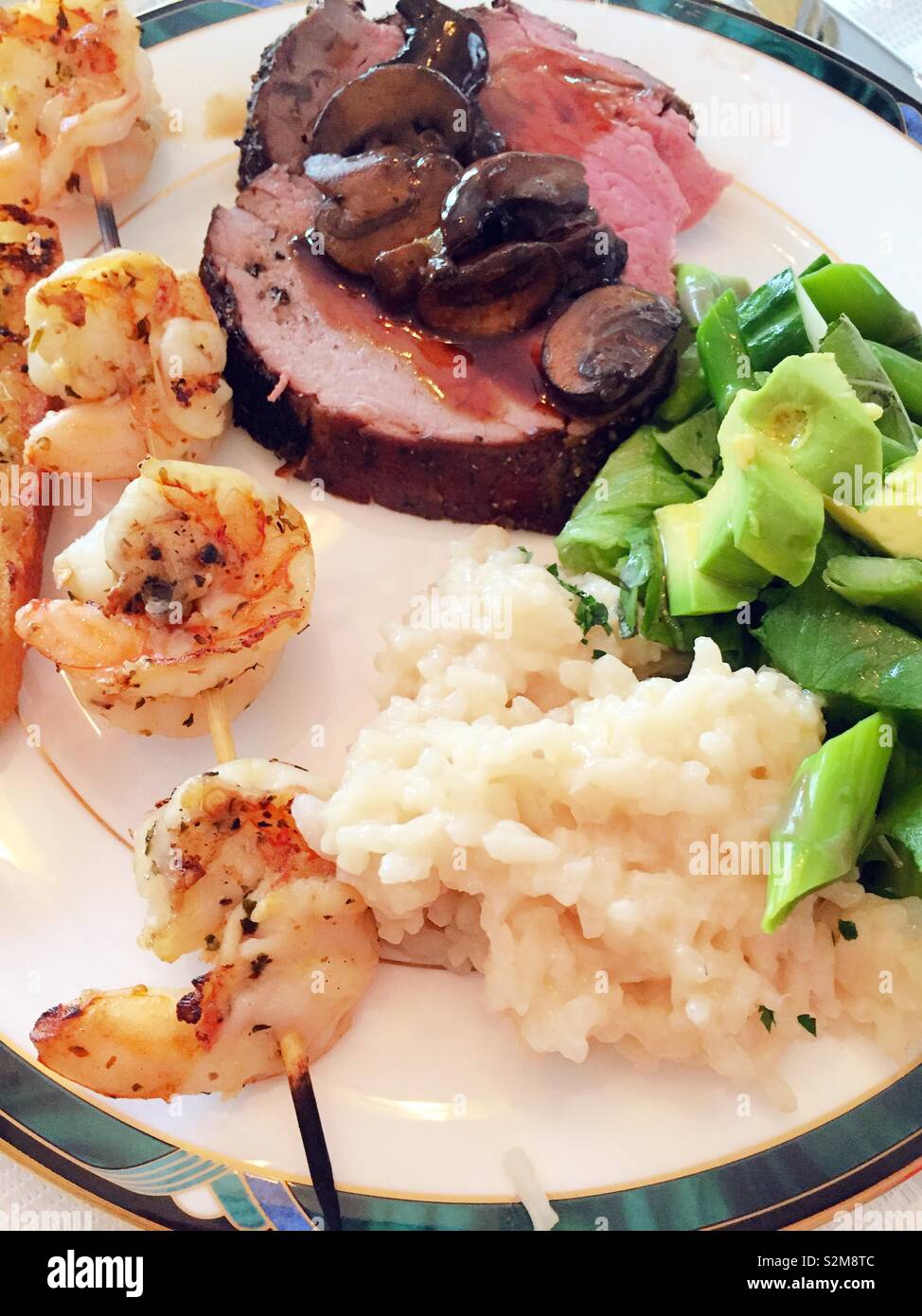 Close up flat lay of a well-balanced meal of beef tenderloin, shrimp, rice and green vegetables, USA - Smartphone Captured Stock Image