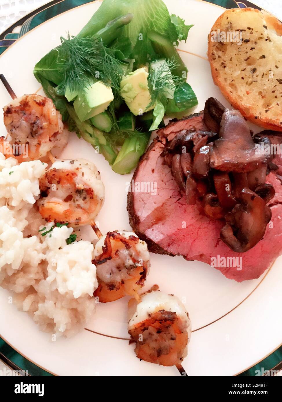 Flat play close up of a well-balanced meal of the beef tenderloin, shrimp on a skewer, salad and rice, USA - Smartphone Captured Stock Image