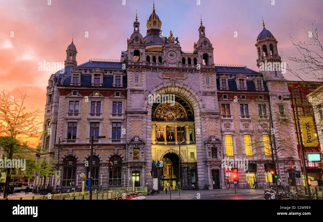 The historic Antwerp central railway station against a dramatic and colorful sunrise sky - Smartphone Captured Stock Image