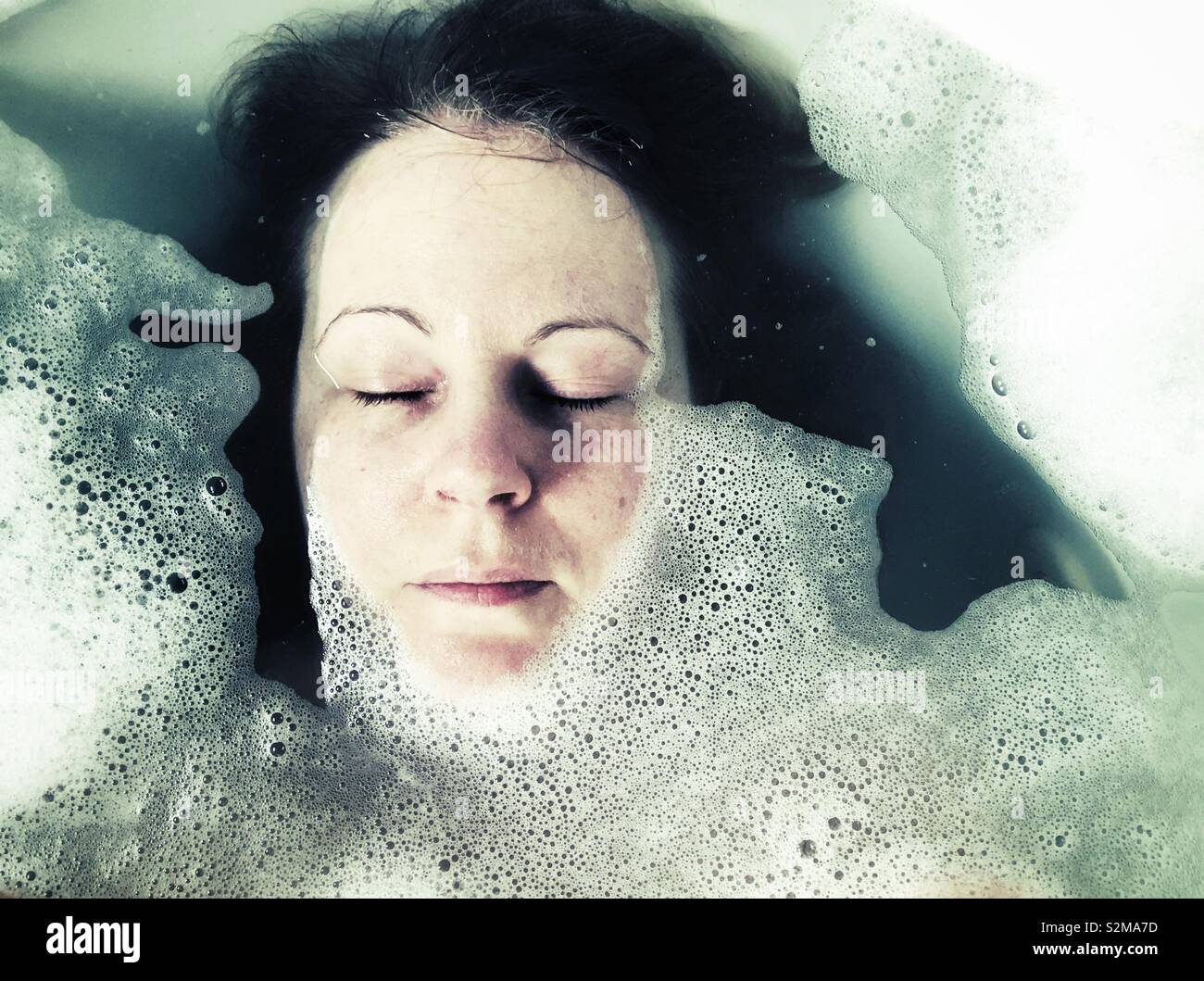 Woman’s face in bubble bath with closed eyes - Smartphone Captured Stock Image