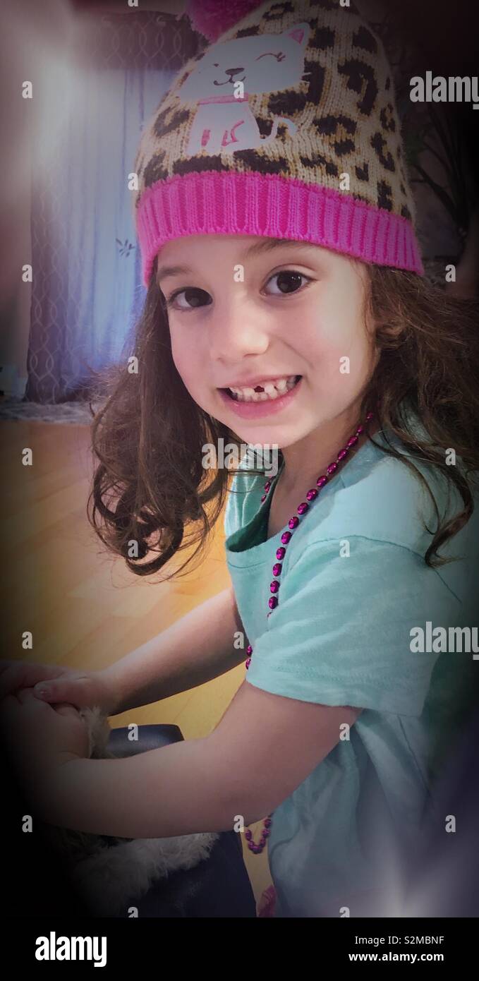 4 year old girl missing a tooth with cute hat Stock Photo