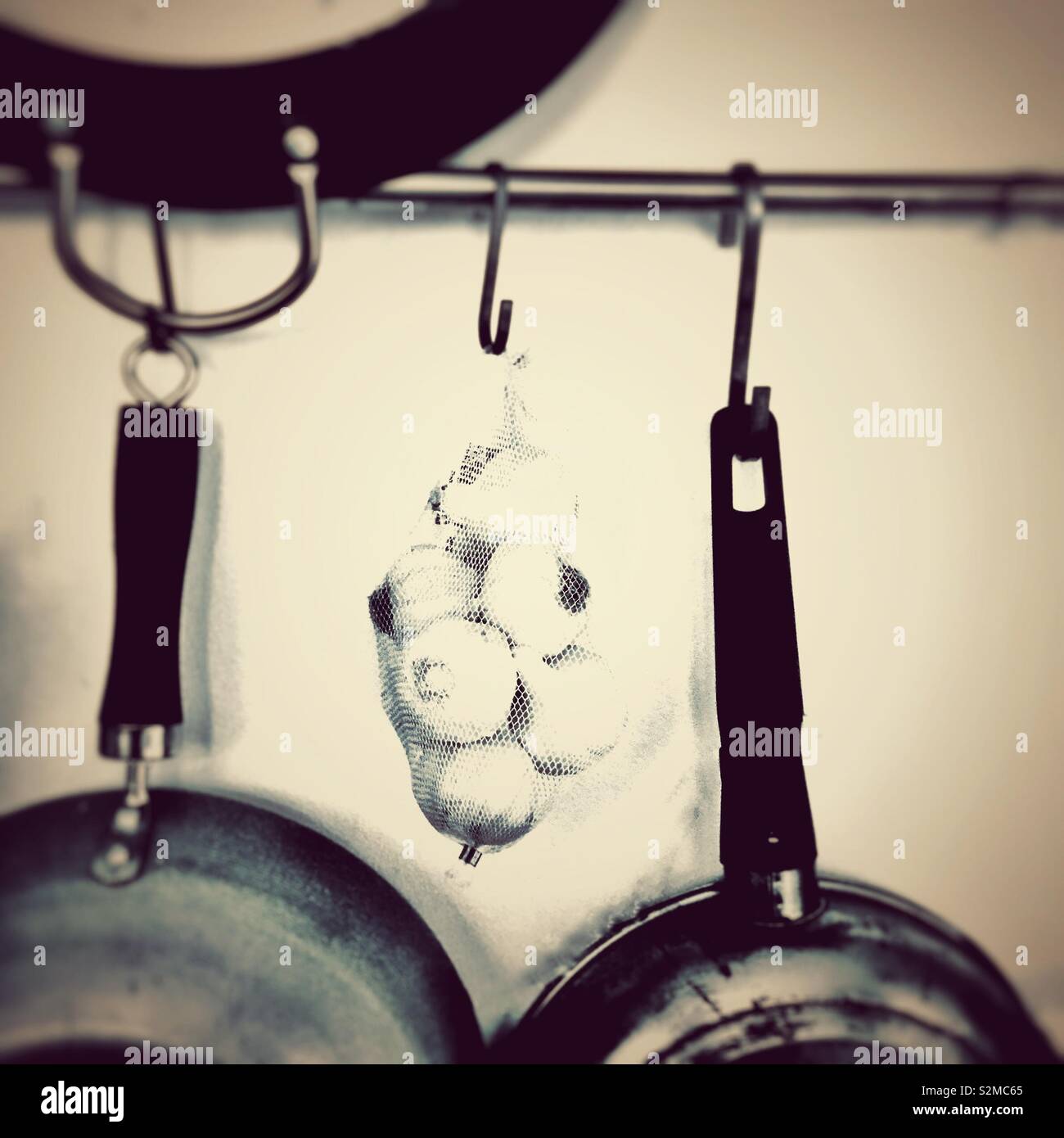 Garlic hanging in a kitchen. - Smartphone Captured Stock Image