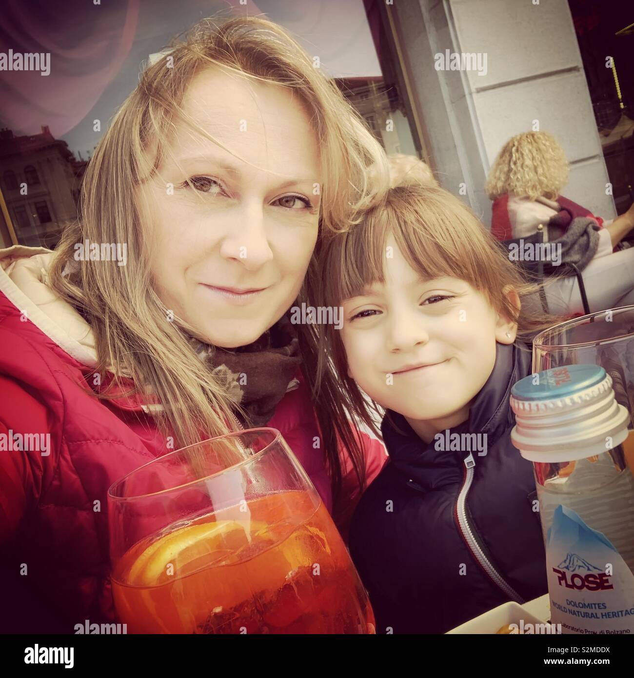 Woman and girl sitting outside in a bar. - Smartphone Captured Stock Image
