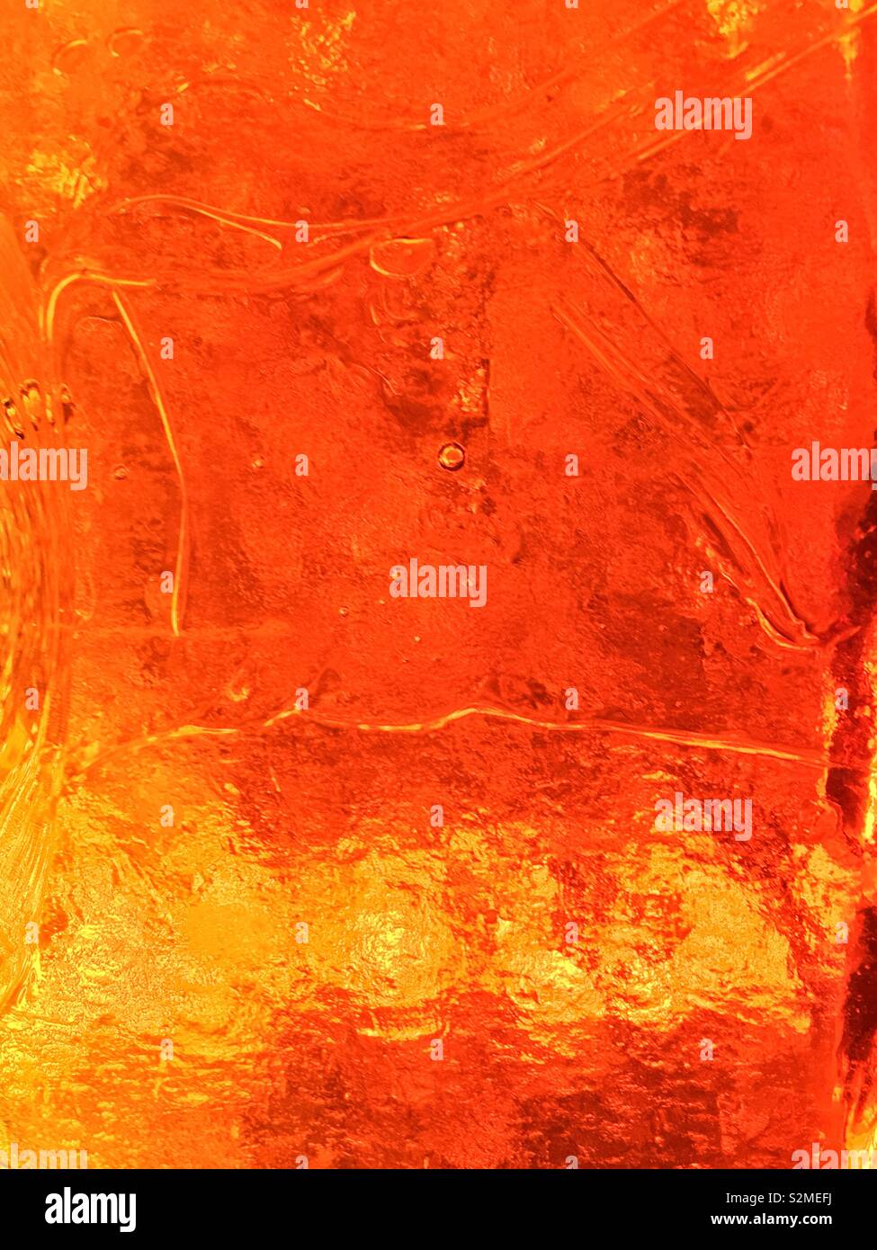 Decorative brightly colored orange and yellow stained textured translucent glass with a random abstract pattern. - Smartphone Captured Stock Image