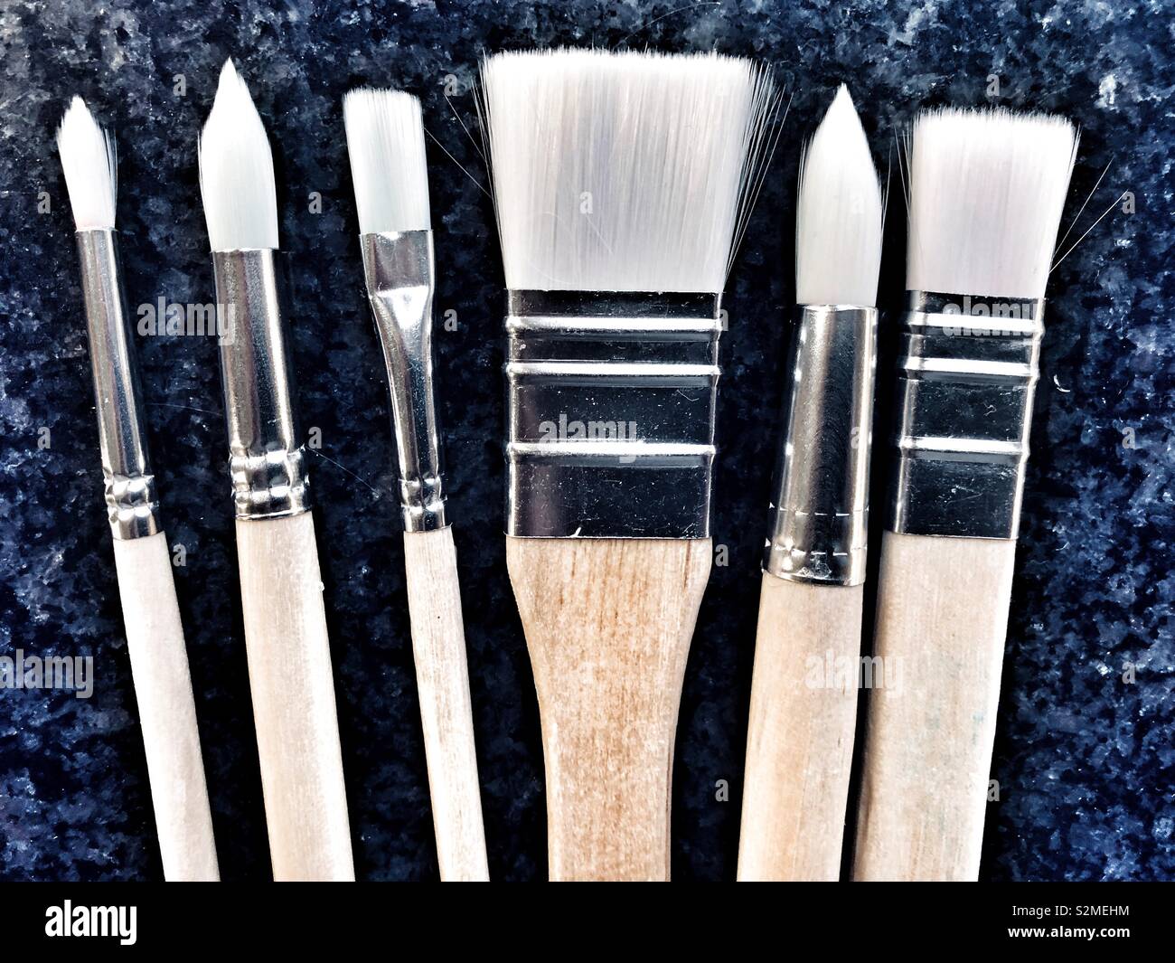 Selection of paint brushes on black granite - Smartphone Captured Stock Image