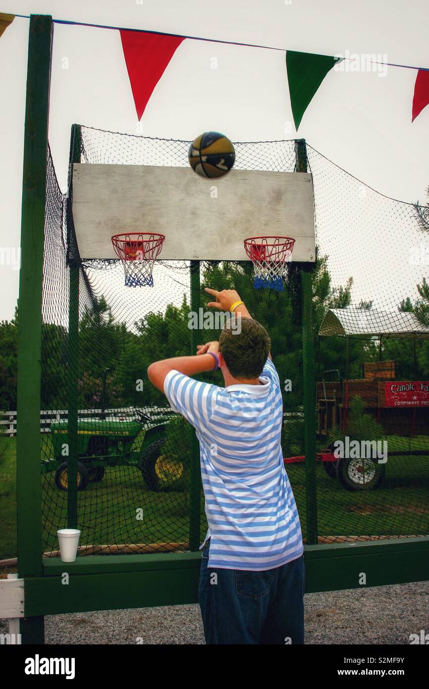 Man throws basketball between two baskets Stock Photo Alamy