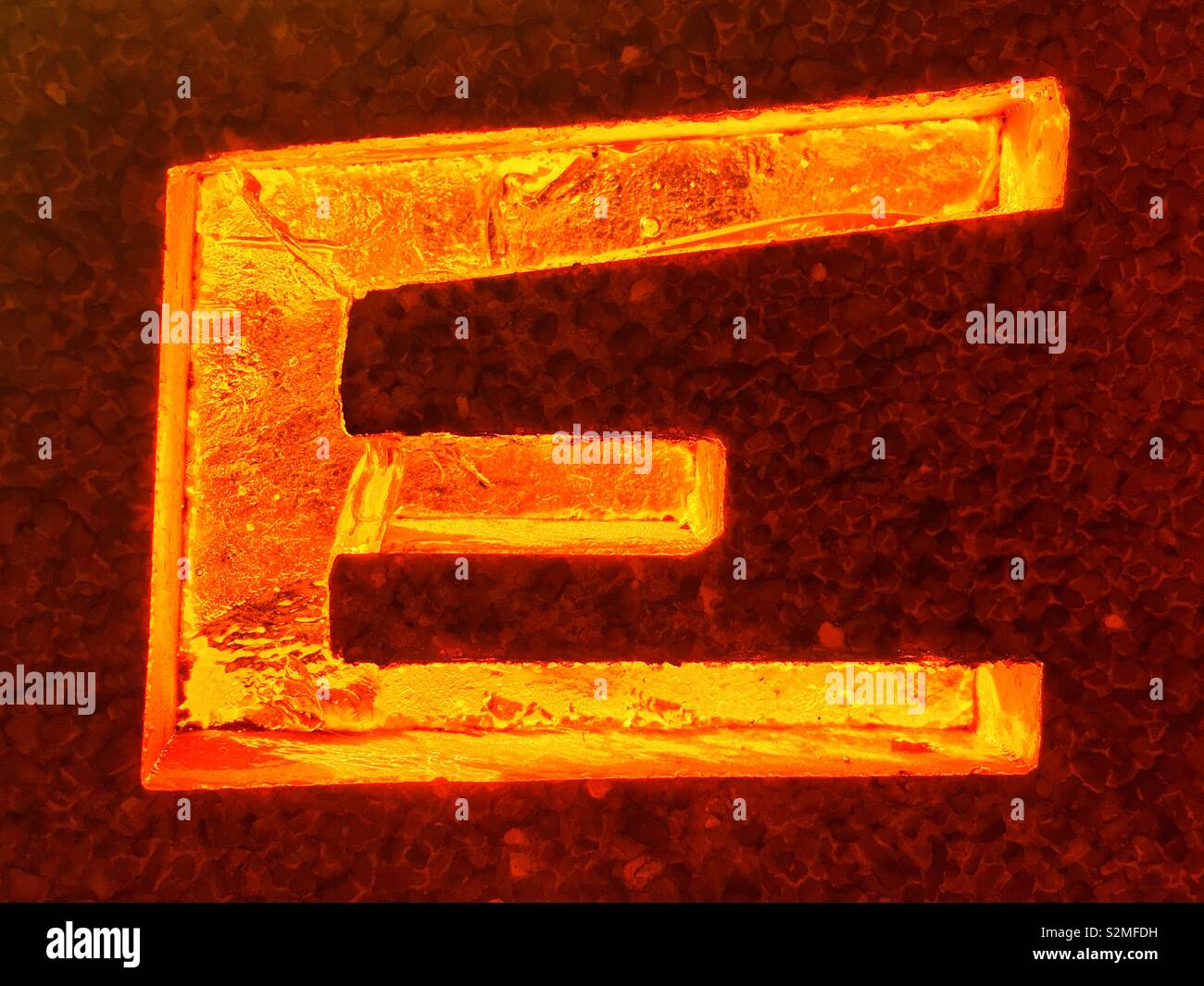 Decorative brightly colored stained textured translucent glass with a capital letter e pattern. - Smartphone Captured Stock Image
