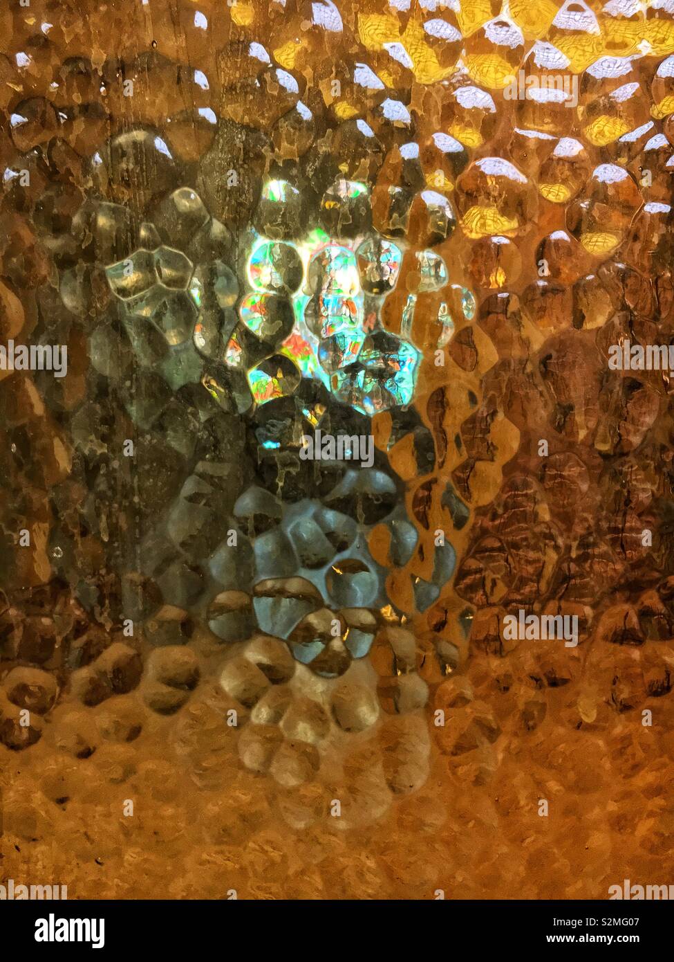 Decorative brightly colored beige stained textured translucent glass with a random abstract pattern. - Smartphone Captured Stock Image