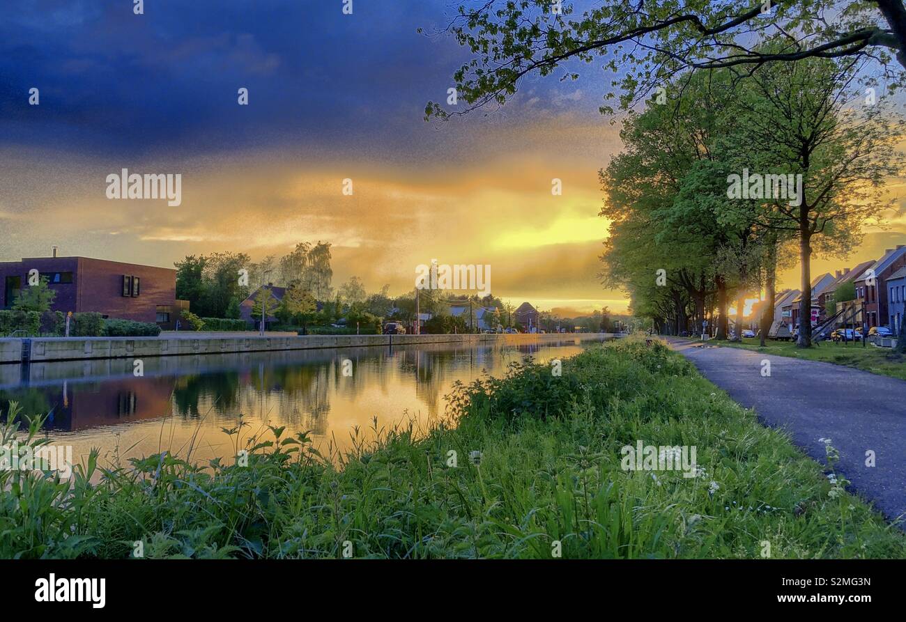 Colorful and dramatic sunrise or sunset over a Countryside river landscape seen from the riverside - Smartphone Captured Stock Image