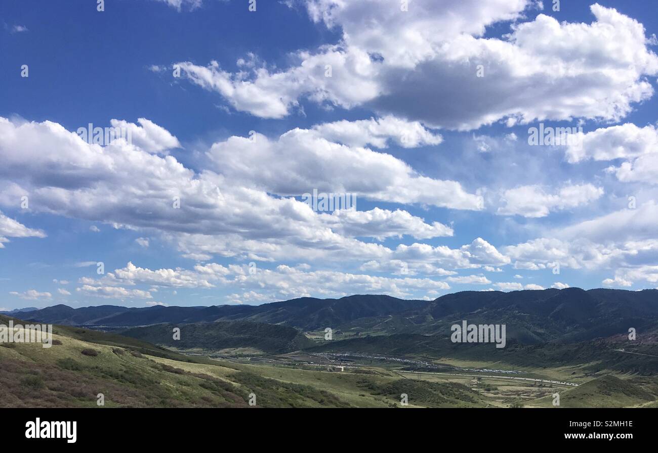 Cloudy skies hovering rolling hills Stock Photo