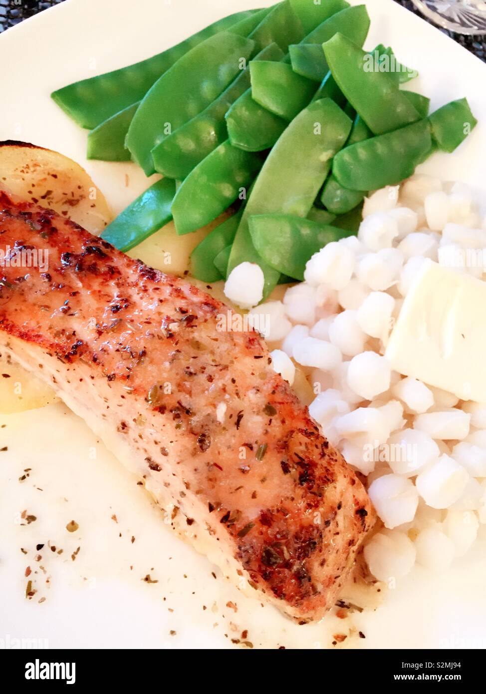 Gourmet entrée of seared salmon, snow peas and white hominy, flat lake close up - Smartphone Captured Stock Image