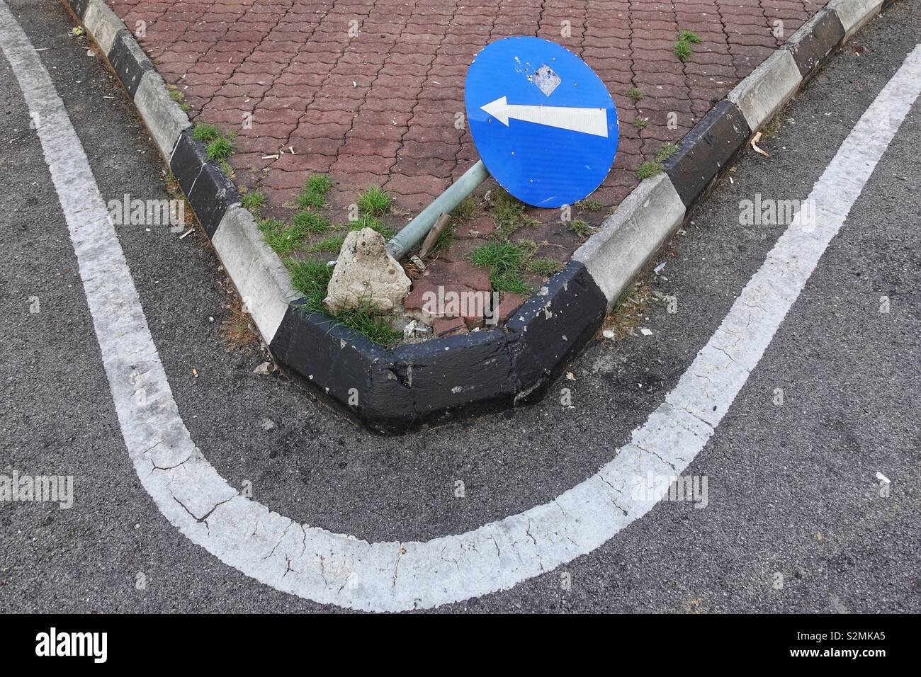 overturned street sign on a traffic island Stock Photo