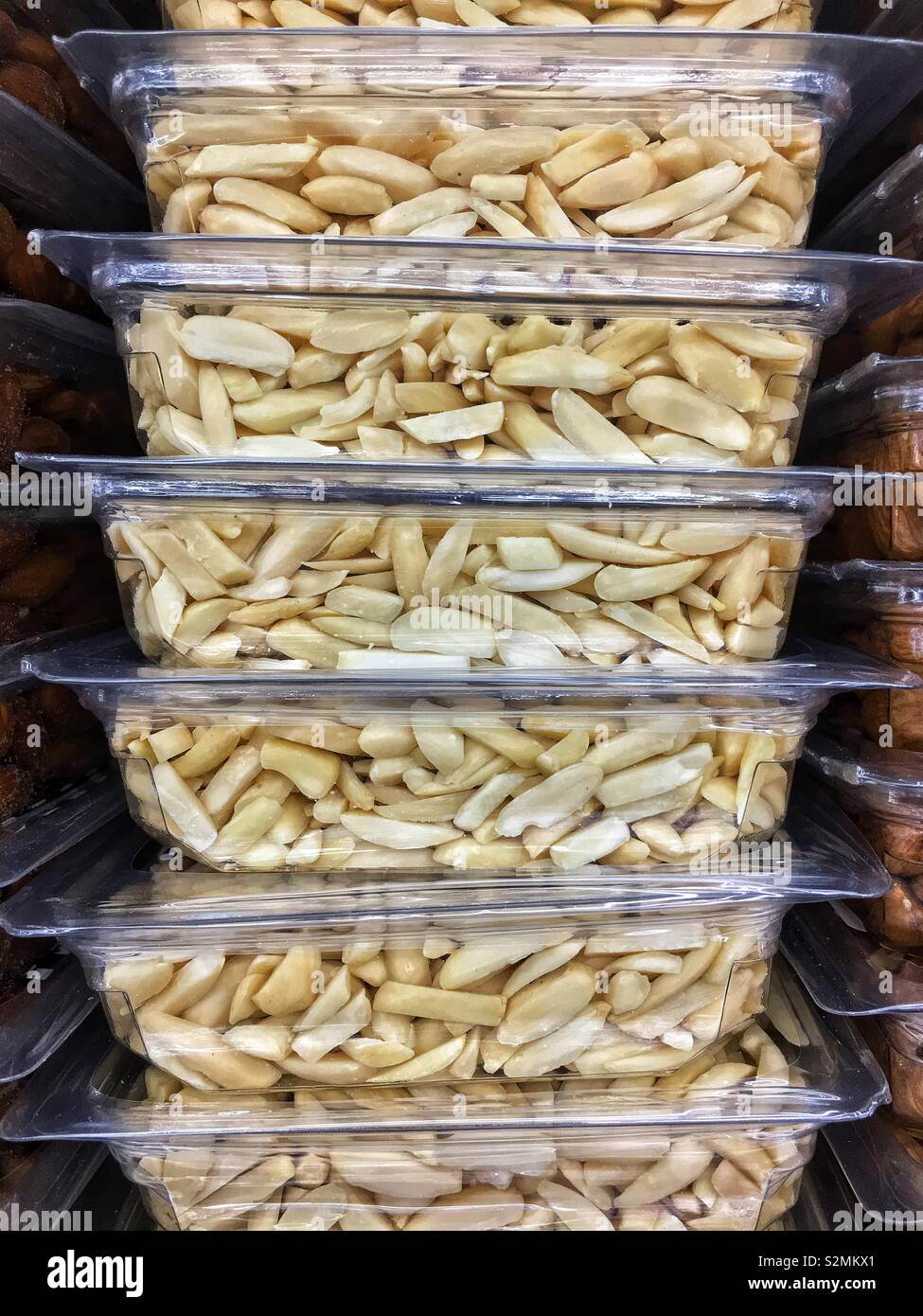 Stacked plastic containers full of slivered almonds on display and for