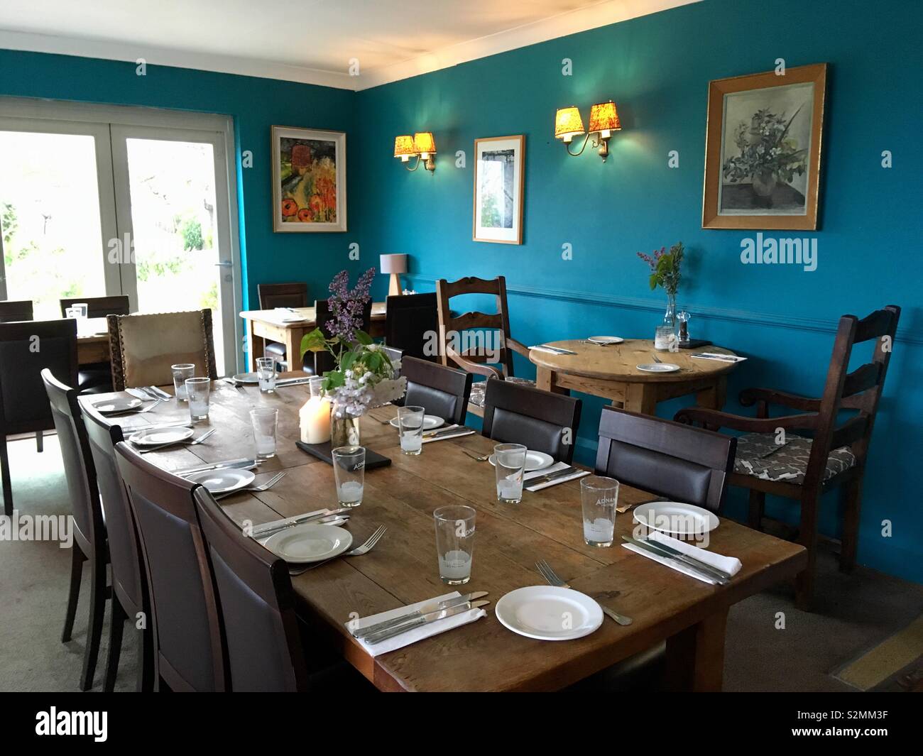 Dining table with place settings with a blue wall - Smartphone Captured Stock Image