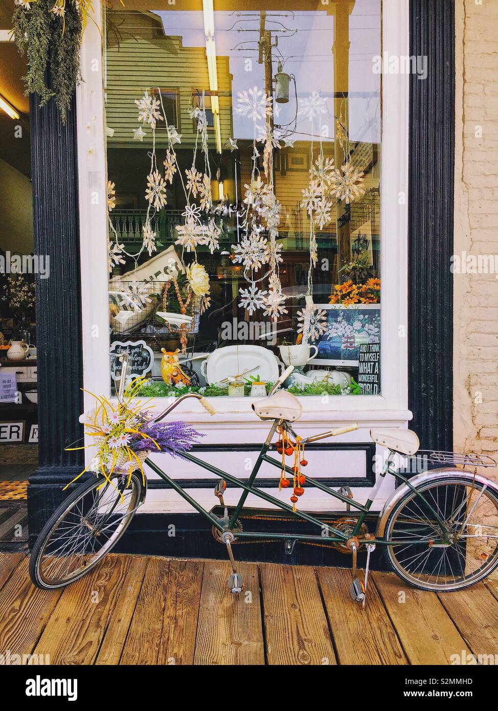 Double rider antique bike in front of a vintage store. Stock Photo