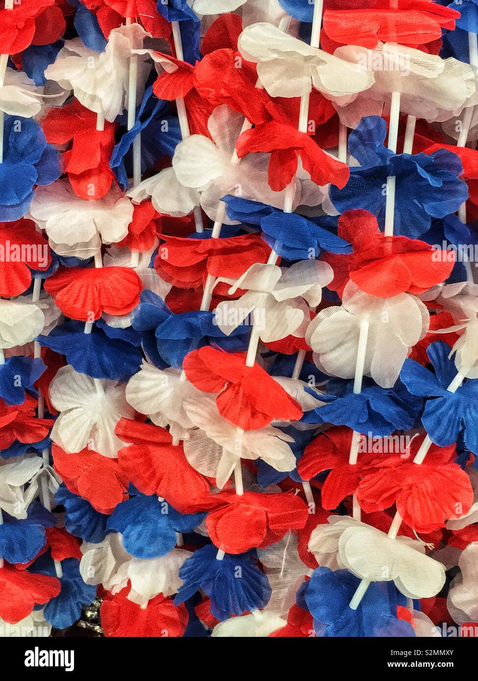 Red, white, and blue flower leis necklaces to celebrate the Fourth of July in the USA. - Smartphone Captured Stock Image