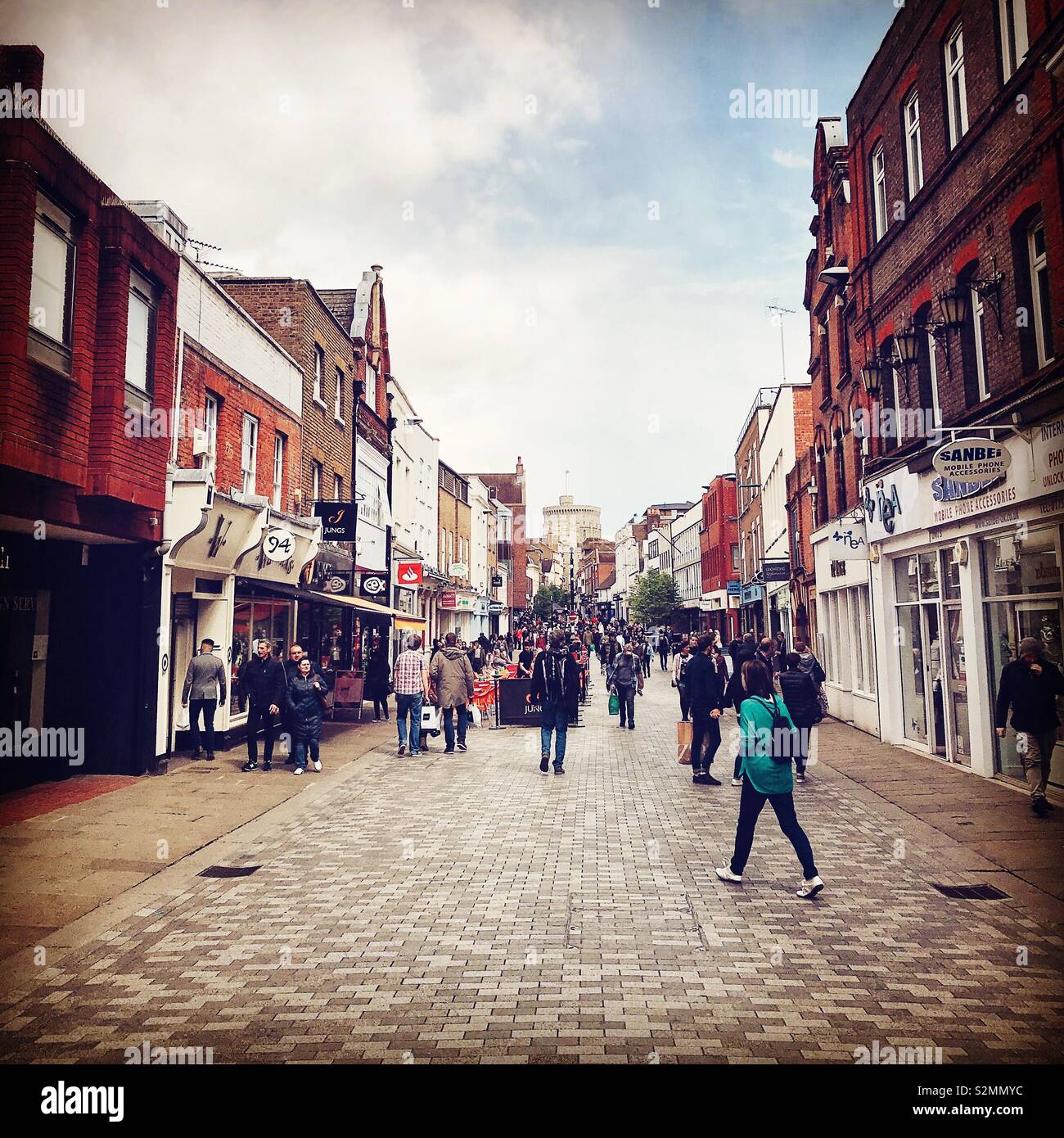 A view up Peascod Street in Windsor looking towards Windsor Castle. Shoppers and tourists are busy passing by. - Smartphone Captured Stock Image