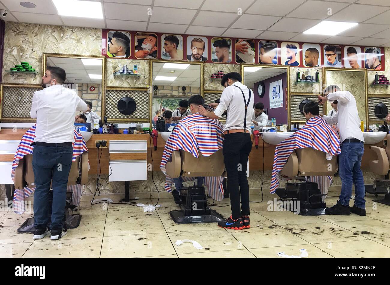 Barbers cutting hair in a barbers shop. - Smartphone Captured Stock Image