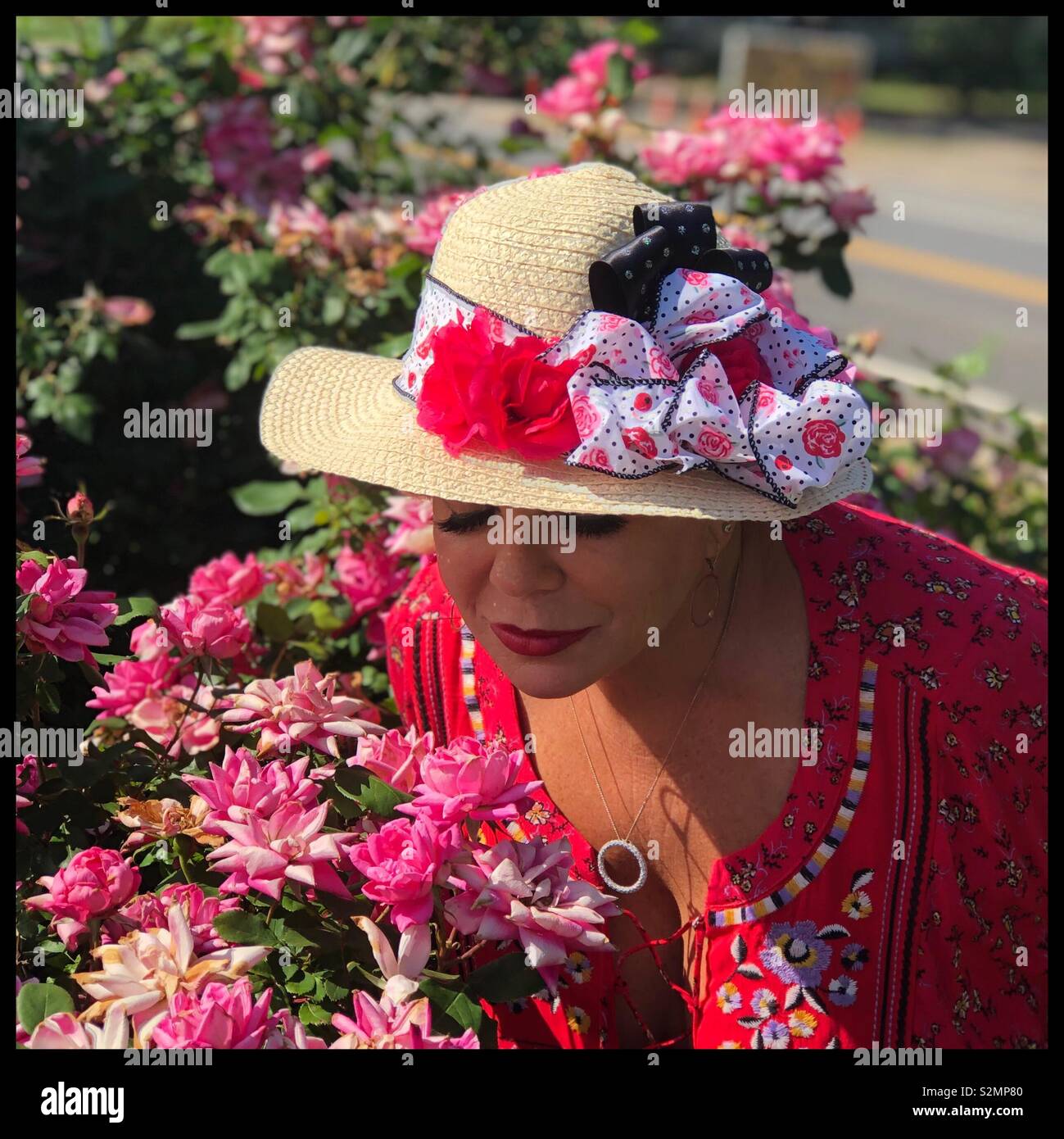 Woman in pink hat smelling Stock Photo