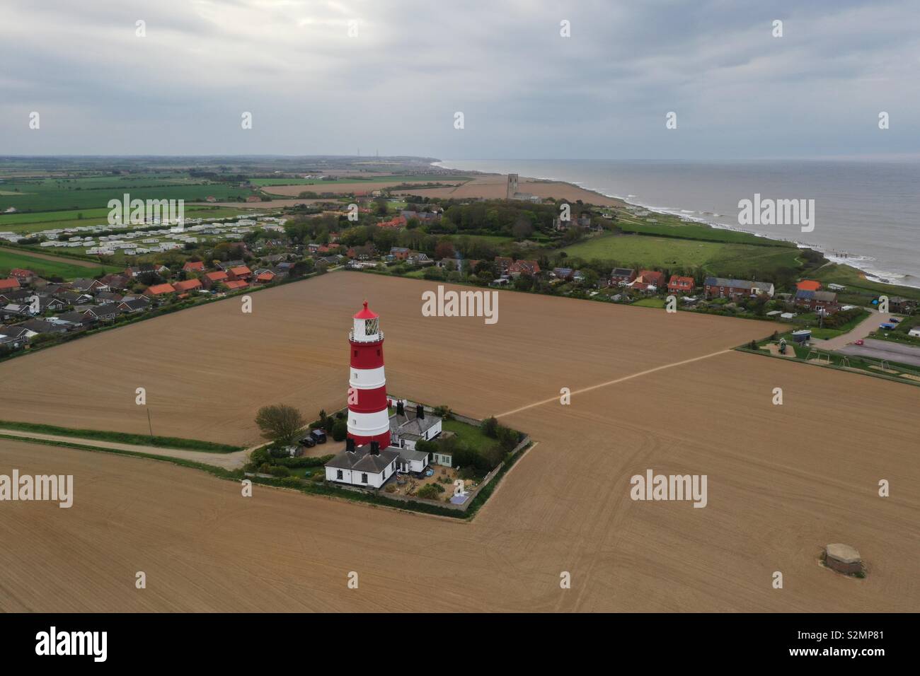 Aerial image of Happisburgh lighthouse in Norfolk at sunset with the sea in the background - Smartphone Captured Stock Image