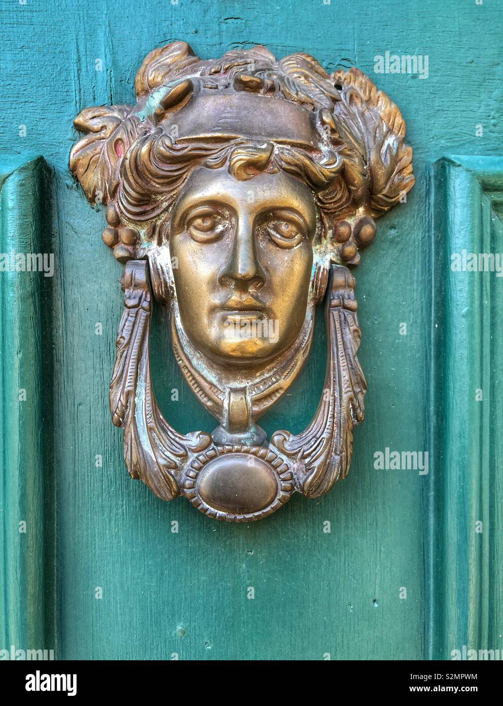 A historical bronze door knocker. - Smartphone Captured Stock Image