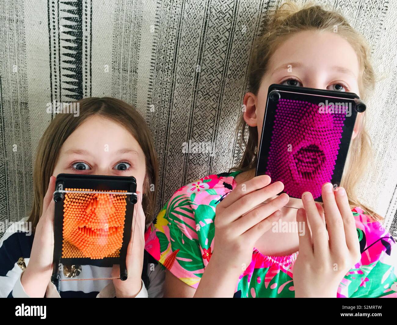 Two sisters with pinart in front of faces - Smartphone Captured Stock Image