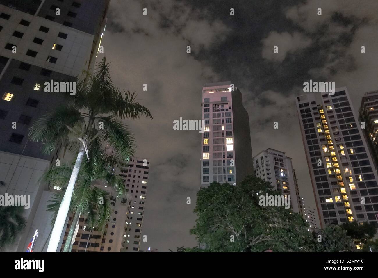 Kuala Lumpur by night - some block of flats, apartment buildings with a dramatic sky and some trees. Stock Photo