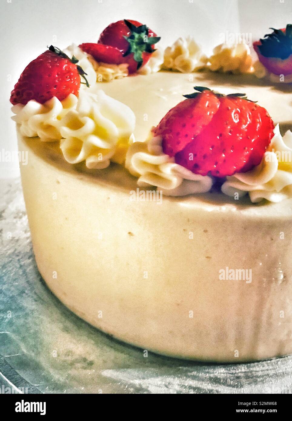 Cake with butter icing and strawberries Stock Photo